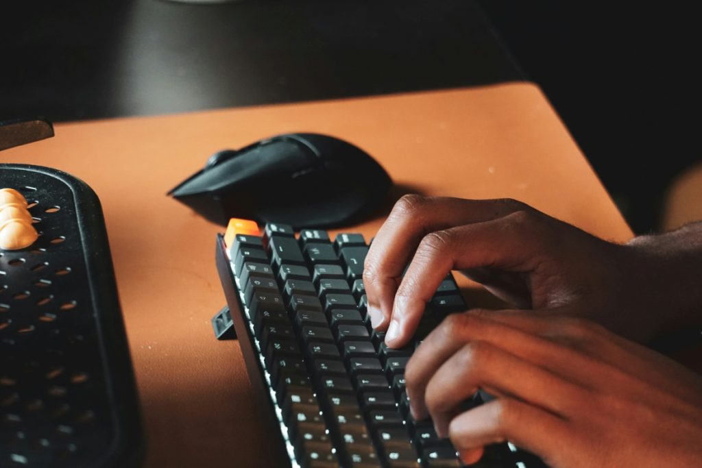 Person typing on a computer keyboard.